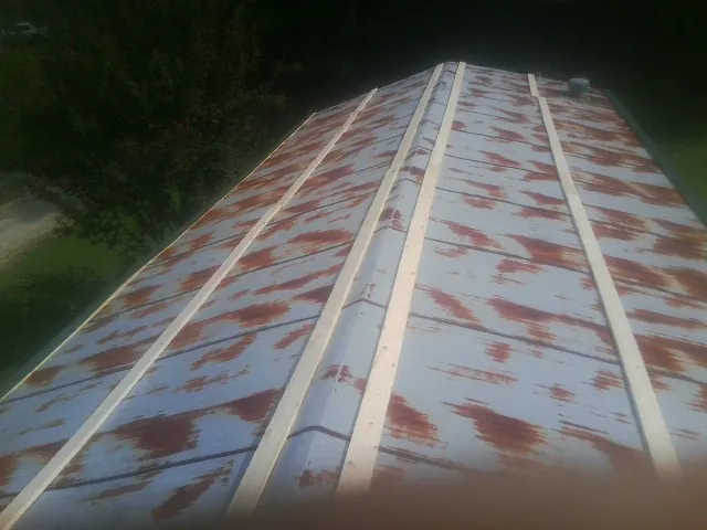 Rusted metal roof panels with new wood purlins before replacement — Storm Damage Roof Repair in Buckley by Roofing Brothers
